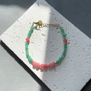 Pastel square-cut natural stone beaded bracelet with gold metal chain on stone base