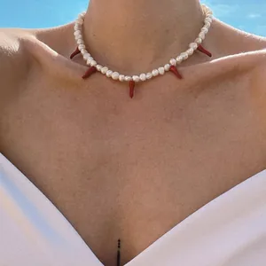 Collier de perles d'eau douce baroques avec pendentifs piment rouge sur le cou