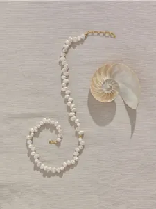 Détail du collier de perles baroques naturelles avec fermoir doré et décor de coquillage