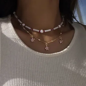 Zweilagige Goldhalskette mit natürlichen Muschelperlen und rosa Blumenanhängern für Damen