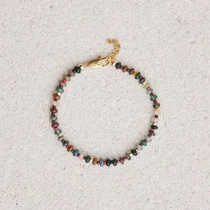 Primer plano del collar bohemio con piedras de colores y detalles de metal dorado