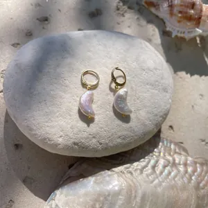 Boucles d'oreilles lune en perles baroques avec anneaux dorés sur des galets