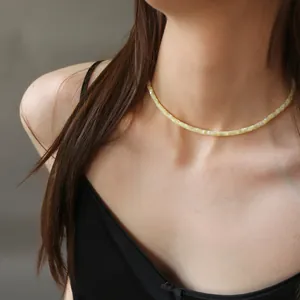 Dettaglio ravvicinato della collana girocollo in perline di conchiglia sul collo