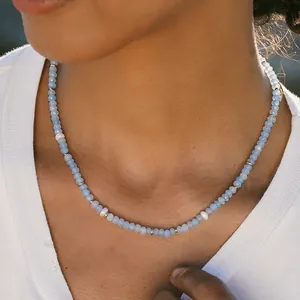 Handmade light blue beaded necklace with freshwater pearls and gold accents on model