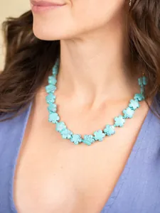 Detailopname van turquoise bloemstenen kralenketting gedragen door een model gids
