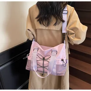 Close-up of light purple nylon crossbody bag with elastic drawstring detail and mesh pocket