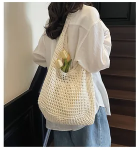 Detail of hand-woven hollow knit tote bag with large mesh texture and shoulder strap