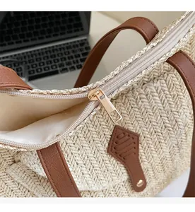 Detailed macro view of the smooth metal zipper and beige woven texture on the straw bag