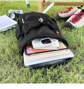 Draufsicht eines schwarzen Nylon-Rucksacks auf Gras mit viel Platz für Laptops und Bücher