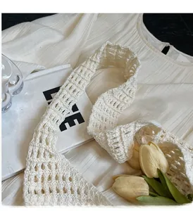 Close-up of cream white crochet tote bag with hollow knit texture and sturdy handle strap