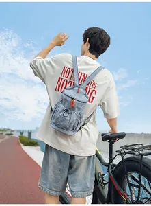 Detail eines graublauen Nylon-Rucksacks mit orangefarbenen Zippern im Freien