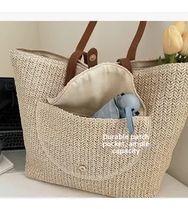 Detail of durable patch pocket and ample capacity showing an umbrella inside the straw bag