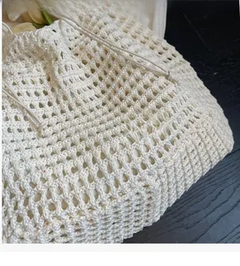 Close-up of knit fabric texture and drawstring detail on off-white woven tote bag