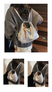 Détails d'un grand sac à dos argenté brillant avec gland en cuir marron et plaque de logo