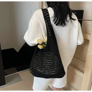 Detail of black hollow crochet tote bag showing woven mesh texture and shoulder drop