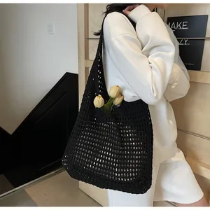 Close-up of black hollow crochet knit tote bag showing intricate woven mesh texture