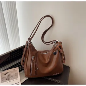 Détails du sac hobo en cuir marron avec fermeture à glissière à pompon et breloque en T