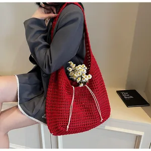 Detailed knit of red hollow-out crochet tote bag with elegant white drawstring ties