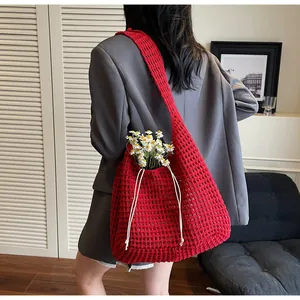 Detail of red hollow woven tote bag with white drawstring and knitted mesh texture