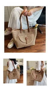 Close-up of woven paper rope tote with brown leather strap and decorative front pocket