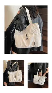 Detail of white large capacity tote bag with drawstring pockets and adjustable side straps