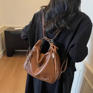 Sac hobo polyvalent en cuir marron foncé pour femme avec pompon et finitions argentées