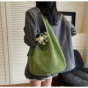 Close-up of green crochet woven mesh tote bag featuring hollow knit texture and daisy decor