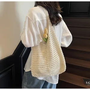 Detail shot of beige hollow woven tote bag with mesh texture and floral decoration