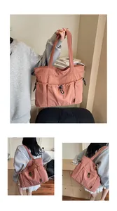 Detail of rose pink nylon tote bag with drawstring front pockets and shoulder straps