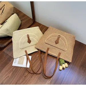 Detailed V-weave texture and leather buckle on straw shoulder tote bags in two colors
