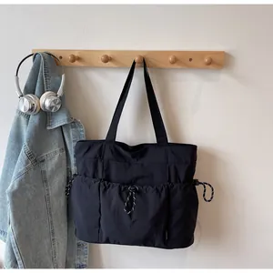 Macro shot of durable black nylon tote bag with functional drawstring and front pocket detail