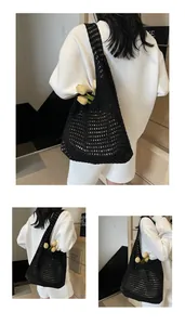 Macro shot of black hollow-out woven crochet tote bag with tulip flower details