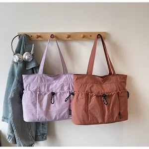 Nylon tote bags in purple and red featuring functional drawstring side pockets for daily use