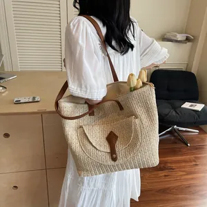 Minimalist straw woven tote bag with brown leather straps and front pocket detail
