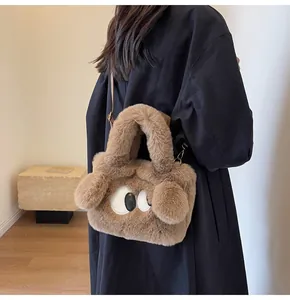 Dettaglio della borsa in peluche marrone con grandi occhi e tracolla a catena sottile