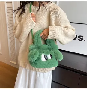 Dettaglio della mini borsa in ecopelliccia verde con occhi a cartone e tracolla lunga