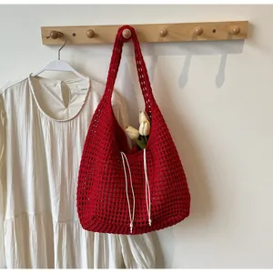 Close-up of red crochet tote bag with hollow woven texture and white drawstring
