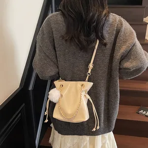 Sac seau chic blanc crème avec cordon de serrage, chaîne dorée et pompon décoratif