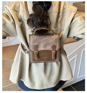 Detailed back view of vintage-style mini backpack with gold buckles and brown straps