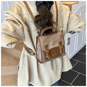 Detailed back view of vintage brown leather backpack worn by model in minimalist setting