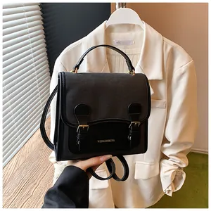 Close-up detail of a stylish retro black women's backpack with elegant gold buckles