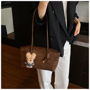 Sac cabas en daim marron avec logo doré, nœud en métal et breloque chien peluche