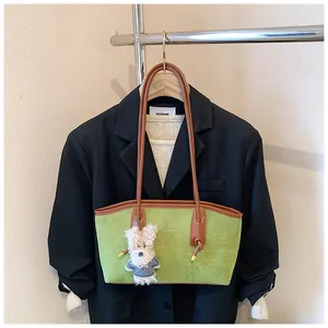 Sac à bandoulière en daim vert avec un pendentif ours blanc et bordures en cuir brun