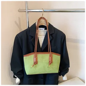 Détail du cabas en daim vert citron avec bandoulière en cuir marron noué et métal doré