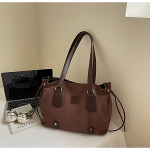 Brown faux suede tote bag shown with a laptop and book in a lifestyle office setting