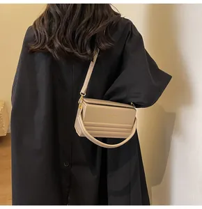 Bolso caja de cuero caqui con letras doradas al hombro para ver estilo y tamaño