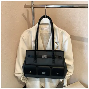 Detail view of the multi-pocket design and silver turn-lock hardware on the tote bag