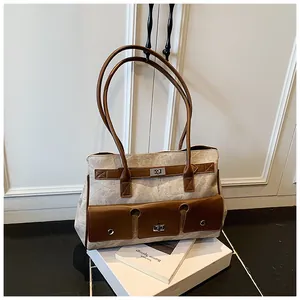 Detailed view of large vintage canvas tote bag with leather trim and metal twist locks