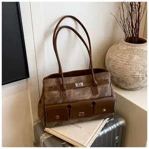 Detail of vintage large brown tote bag with metal buckles and textured pockets