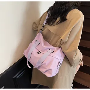 Back view of model wearing a large lavender nylon messenger bag on a wooden staircase